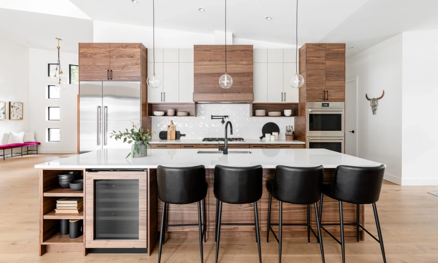 Walnut and white kitchen cabinetry with a large island and black stools