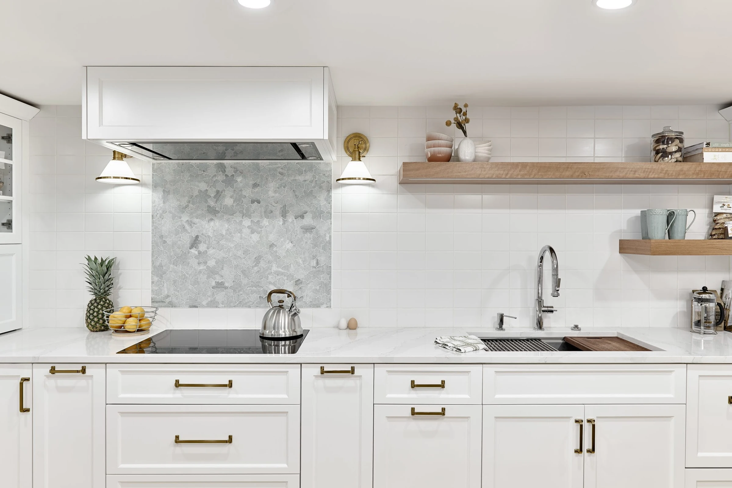 White kitchen cabinetry with open timber shelves and subtle brass hardware