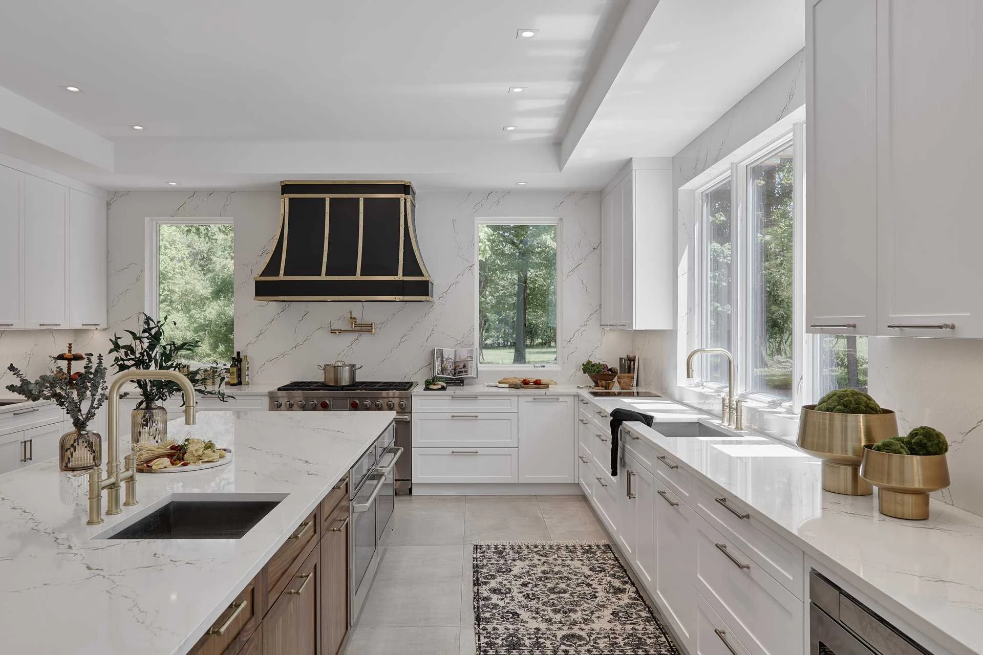 White kitchen cabinetry with dark range hood and natural light