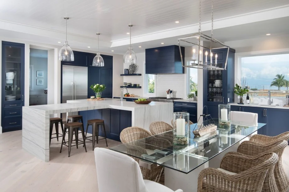 Deep blue cabinetry and a stone island in a bright coastal kitchen