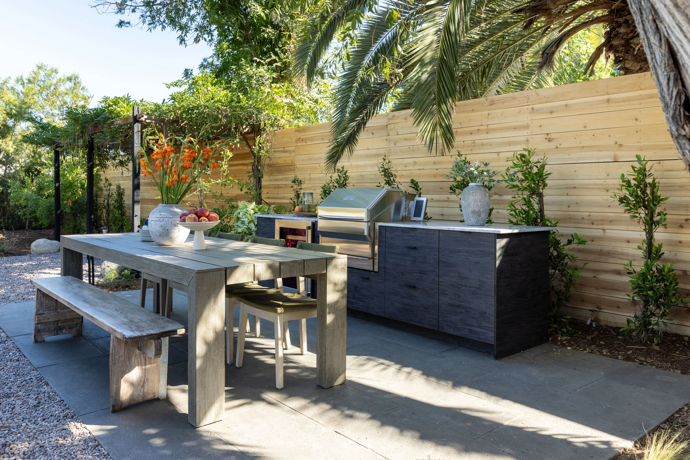 Charcoal outdoor cabinetry and grill in a lush garden setting